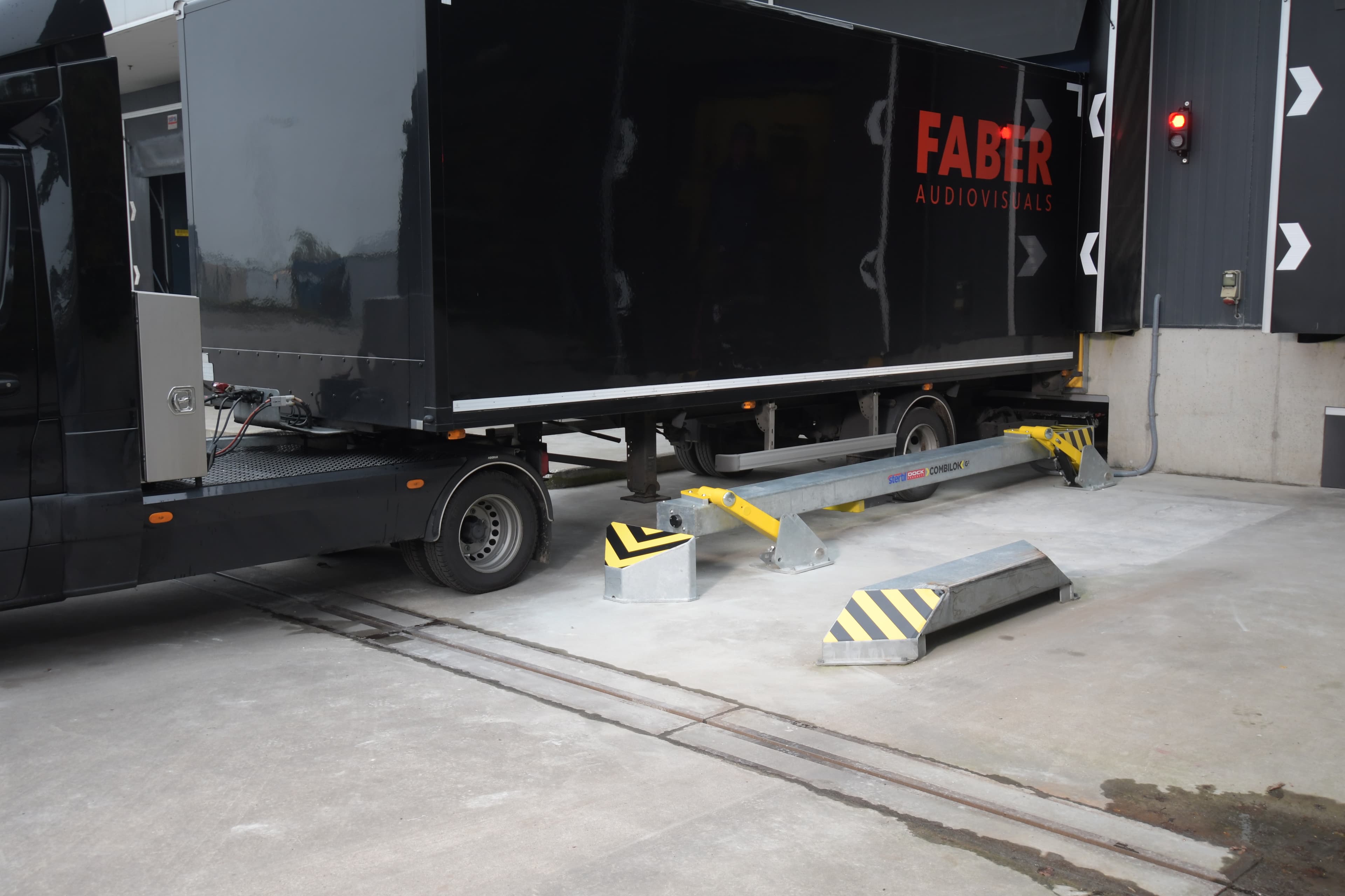 Universal automatic vehicle restraint COMBILOK G2 from Stertil Dock Products restraining a truck at the loading bay